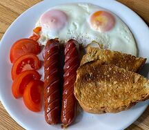 Яичница с колбасками, томатами и тостом