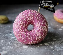 Донат с розовой глазурью и посыпкой из белого шоколада