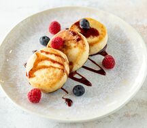 Безлактозные сырники с финиковым сиропом и свежими ягодами
