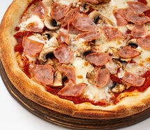 Пицца с ветчиной и грибами на тонком тесте