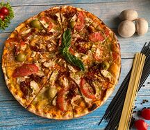 Пицца с курицей, вялеными томатами и песто