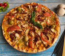 Пицца с курицей, вялеными томатами и песто