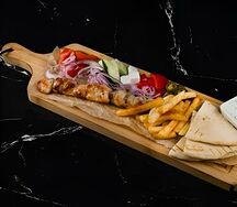 Сувлаки куриный на тарелке с соусом