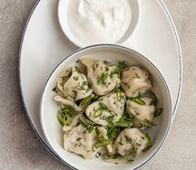 Отварные пельмени со сметаной и зеленью