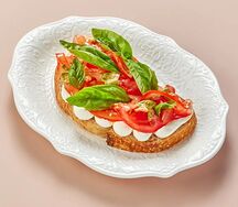 Брускетта с крем-чизом, томатами, соусом песто и базиликом