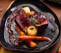 Говяжья вырезка под малиновым соусом с овощами конфи 