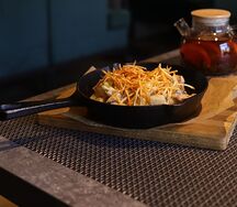 Сковорода с филе из куриного бедра, беконом, картофелем и лесными грибами