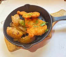 Сковородка с куриным шницелем и картофельными дольками