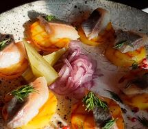 Каспийская сельдь на печеном картофеле с маринованным луком