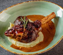 Голяшка ягнёнка, томлённая в красном вине, с картофельным пюре