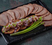 Язык говяжий с солодовыми чипсами, зеленым луком и хреном