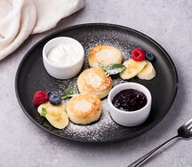 Сырники с фруктами, сметаной и джемом