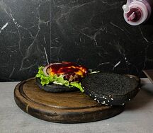 Черный бургер с говяжьей котлетой и брусничным соусом