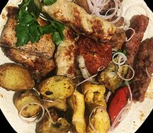 Садж из пяти шашлыков и овощами на мангале