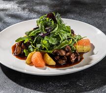 Теплый салат из куриной печени с яблоком, миксом из зелени и грейпфрутом под соусом демиглас