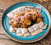Сельдь на деревенском картофеле с ялтинским луком и брусникой