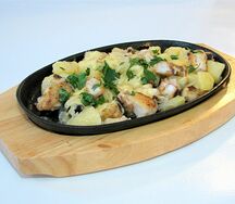 Сом с картофелем под сыром, маринованными огурцами и луком