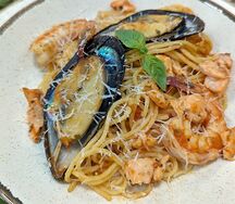 Черные спагетти с морепродуктами в томатном соусе