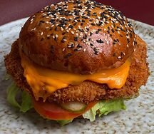 Бургер с куриным шницелем, солёным огурчиком и сыром чеддер