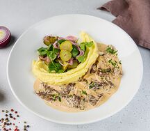 Бефстроганов с картофельным пюре, маринованными огурцами и луком с кинзой