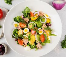 Большой Нисуаз с тунцом, картофелем, перепелиным яйцом, томатами, листьями салата и красным луком