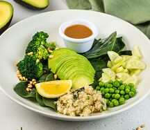 Большой зеленый салат с авокадо, киноа, брокколи, свежими огурцами, молодым горошком и шпинатом