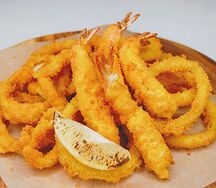 Креветки, кальмары и луковые кольца в кляре