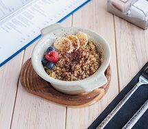 Цельнозерновая овсяная каша с ягодами, бананом, орехом и шоколадом