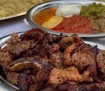 Plats de porc braisé, attiéké et une boisson 