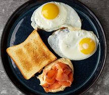 Яичница с хумусом, семгой и хлебом бриошь