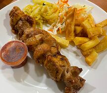 Шашлык из курицы с обжаренным картофелем во фритюре, капустным салатом, маринованным луком и томатным соусом