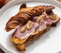 Круассан с пастрами, скрэмблом и медово-горчичным соусом 