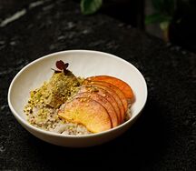 Овсяная каша с киноа, кремом из фисташки и персиками
