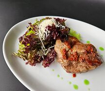 Стейк из свинины с вялеными томатами и миксом салата