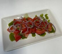 Розовые томаты с фиолетовым луком и оливковым маслом 