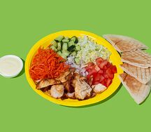 Шаверма на тарелке с обжаренным куриным филе, свежими овощами и морковью по-корейски