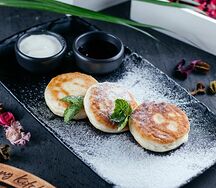 Сырники с брусничным соусом и сезонными ягодами