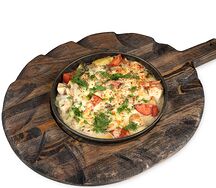 Горячая сковородка с курицей и овощами сливочном соусе