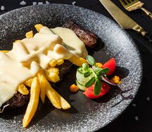 Бон-филе с картофелем фри под горячим сыром