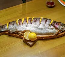 Форель, запечённая на подушке из свежих трав