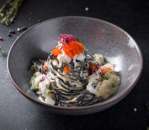 Спагетти с чернилами каракатицы соусом Биск, авокадо и крабом