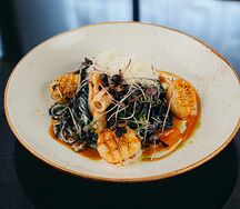 Паста Дель мар с чернилами каракатицы с морским гребешком и командорским кальмаром в лавандовом соусе с сыром пармезан