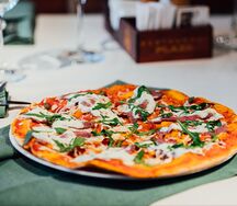 Пицца с пастрами, вялеными томатами, страчателлой и рукколой