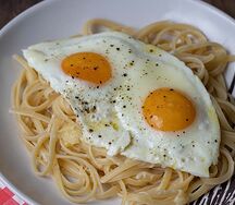 Spaghetti printanier avec légumes sautés et œuf au plat