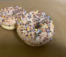 Донатс с белой глазурью и кусочками драже