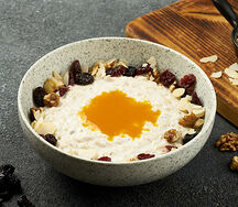 Овсяная каша с пюре из манго, клюквой и грецкими орешками