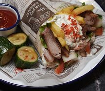 Сувлак с шашлыком из курицы подается с фри и кетчупом