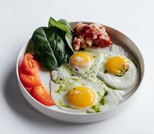 Яичница глазунья с беконом, шпинатом и томатами