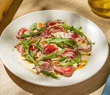 Мини-равиоли с сырным кремом под сливочным соусом с вялеными томатами и руколой