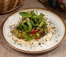 Запечённый баклажан с томатами, рукколой, орехами и кунжутным хумусом 